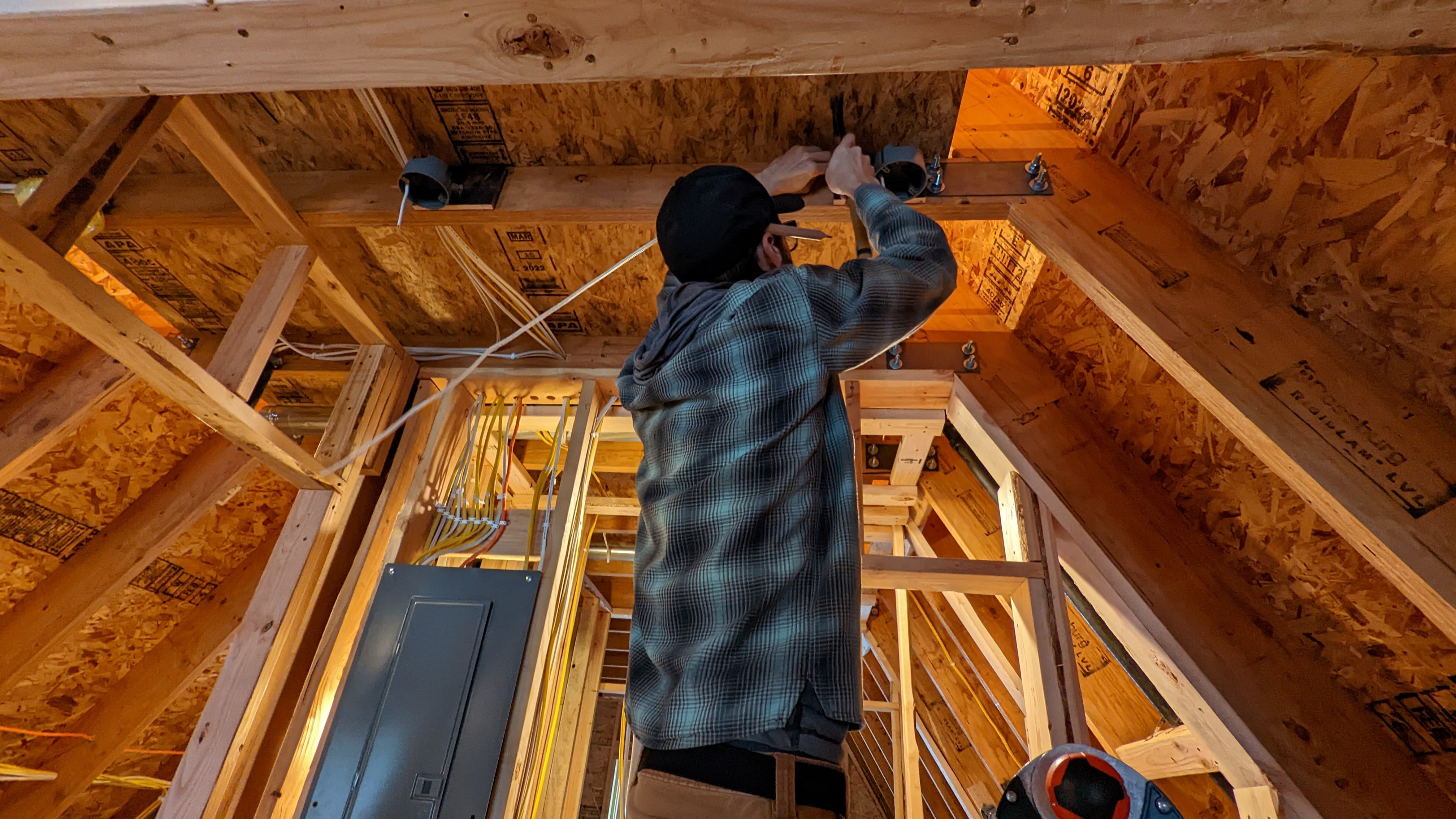 Photo of man wiring a home.
