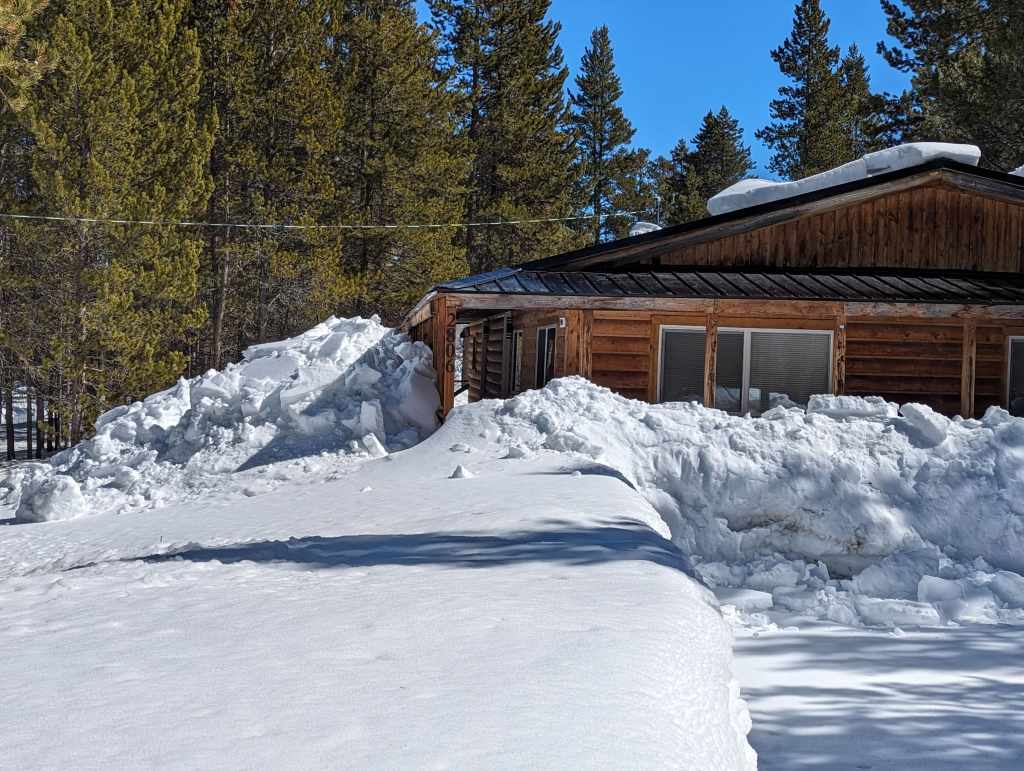 Photo of roof avalanche blocking windows is the sign of a poor cabin roof design.
